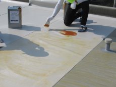 屋上の塩ビシート防水を貼りつける為に専用の接着剤を塗布します。